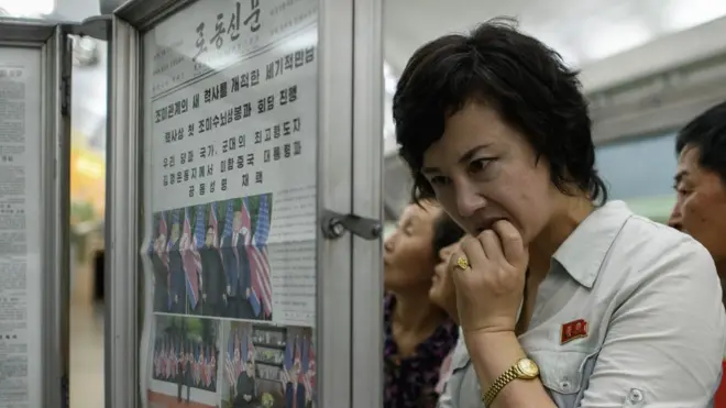 평양의 시민들이 북미정상회담에 대한 노동신문 보도를 읽고 있다