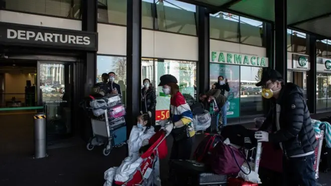 ผู้คนเดินทางออกจากประเทศอิตาลีที่สนามบิน Milan - Malpensa ใกล้เมืองมิลานของอิตาลี