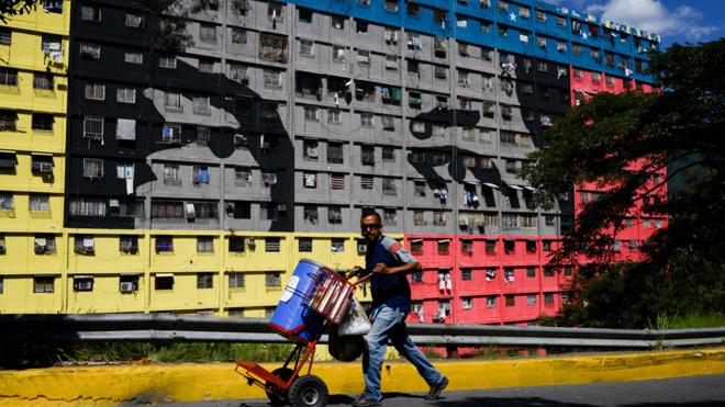 Venezolano en el 23 de enero con la imagen de Chávez de fondo