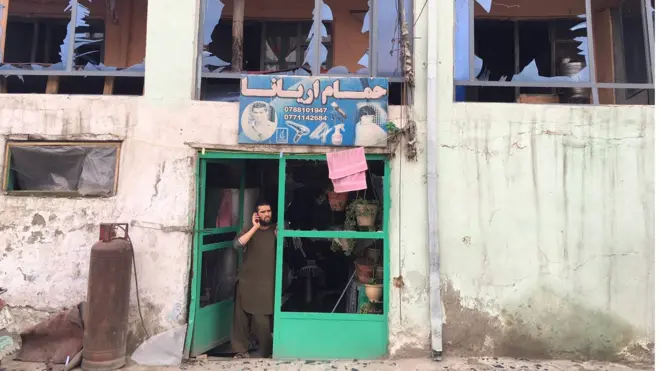 A man stands inside his damaged shop near the scene of a huge bomb blast in central Kabul, Afghanistan, on 19 April 2016