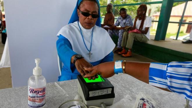 Une sœur catholique se fait prendre ses empreintes digitales pendant l'exercice d'inscription des électeurs de l'INEC au centre Area 10 à Abuja, au Nigeria, le 23 juin.