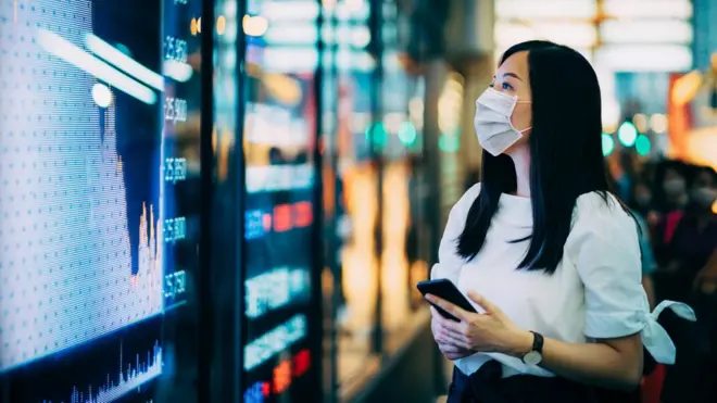 一名女子看着显示股票的屏幕