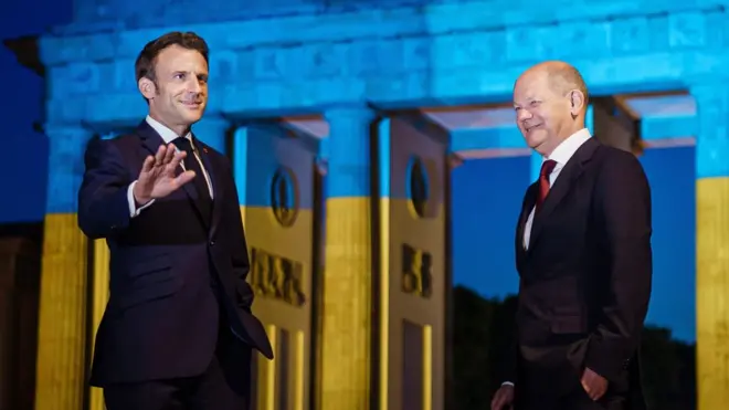 Mr Macron (L) later joined German leader Olaf Scholz in Berlin