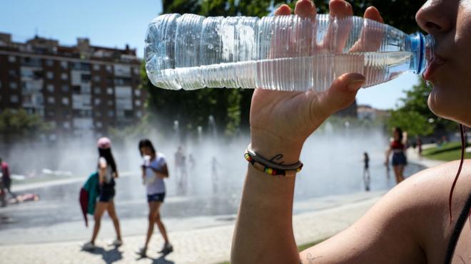 Mujer bebiendo agua durante una ola de calor