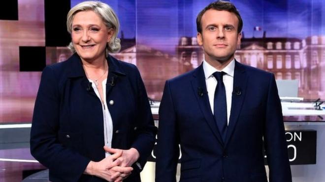 French presidential election candidate Marine Le Pen (L) and Emmanuel Macron pose prior to the start of a live election debate on May 3, 2017