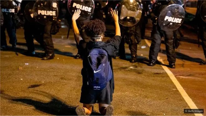 አንድ ታዳጊ ከፖሊሶች ፊት ተንበርክኮ