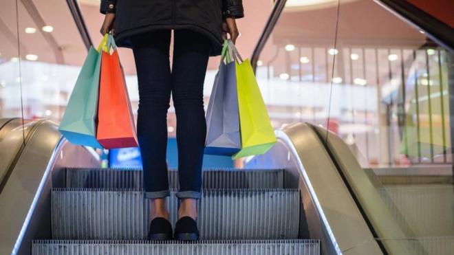 Mujer subiendo una escalera después de comprar.