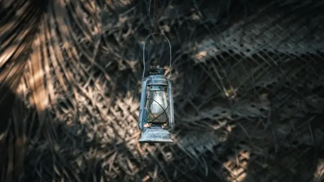 Hurricane lantern hangs outside the village cabana house,