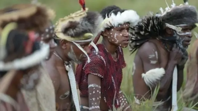 Orang asli Papua tengah mengenakan pakaian adat.