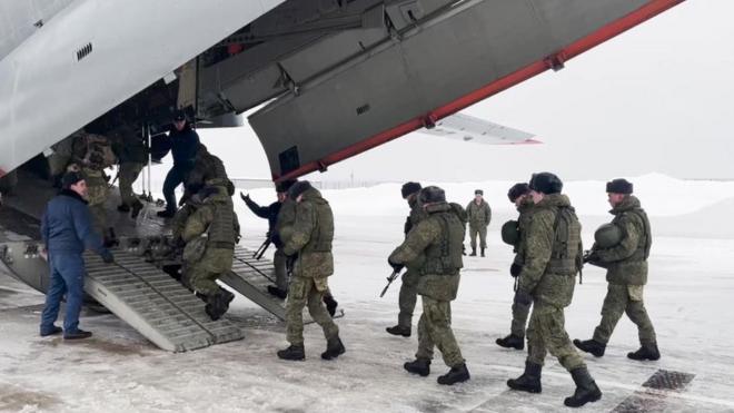 Russian Defence Ministry's press service shows Russian servicemen boarding a military aircraft on their way to Kazakhstan, at an airfield outside Moscow