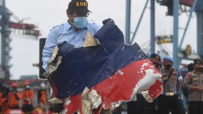 Petugas menata serpihan pesawat Sriwijaya Air SJ 182 rute Jakarta - Pontianak yang jatuh di perairan Pulau Seribu, di Dermaga JICT, Jakarta, Senin (11/1/2021).