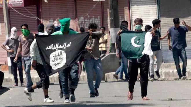 انڈیا کے زیر انتظام کشمیر میں نوجوان بظاہر پاکستان اور دولت اسلامیہ کے پرچم اٹھائے ہوئے (فائل فوٹو)