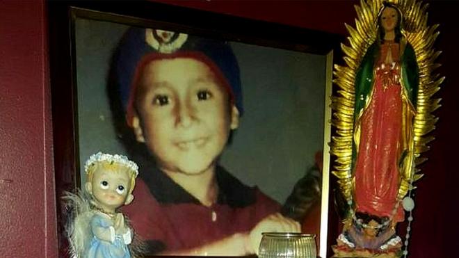 Foto del hijo de Sara Hernández al lado de una imagen de la virgen María.
