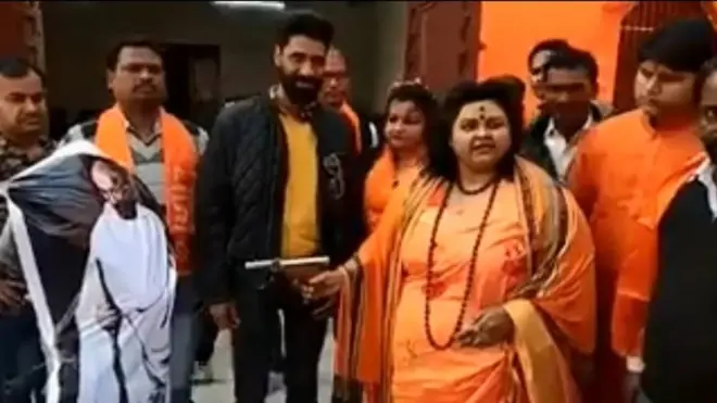 Pooja Pandey, leader of the Hindu Mahasabha, shooting an effigy of Gandhi with an air pistol