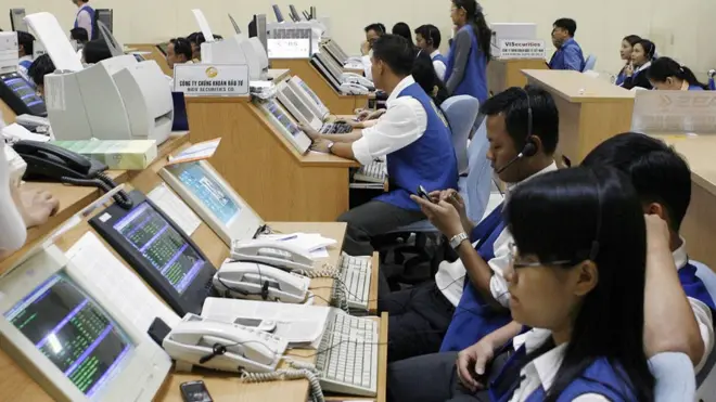 Traders watch a stock index monitors at a Securities Trading Center in Ho Chi Minh City