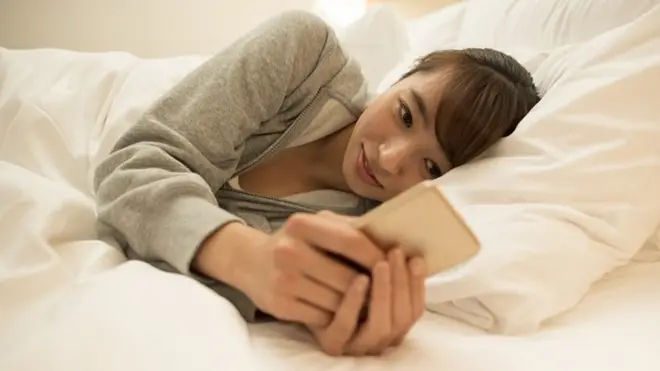 Woman using mobile phone at home