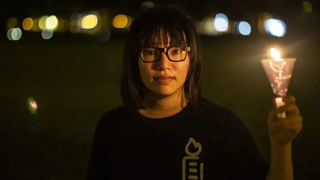 ผู้หญิงใส่แว่นถือเทียน