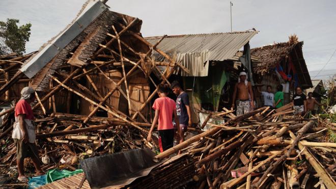 Residents salvage belongings from their destroyed homes in the coastal town of Dulag, Philippines