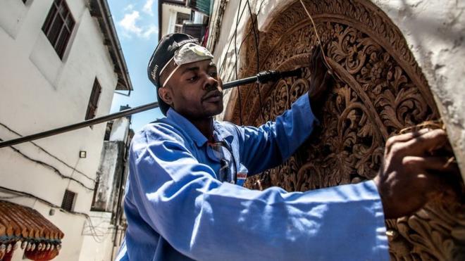 A traditional Zanzibari round-top door is repaired