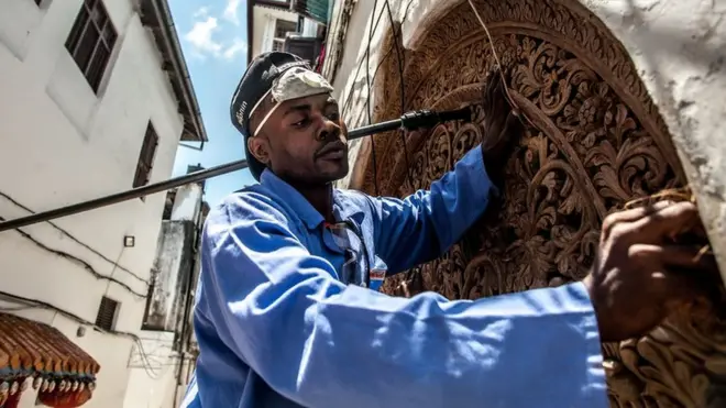 A traditional Zanzibari round-top door is repaired