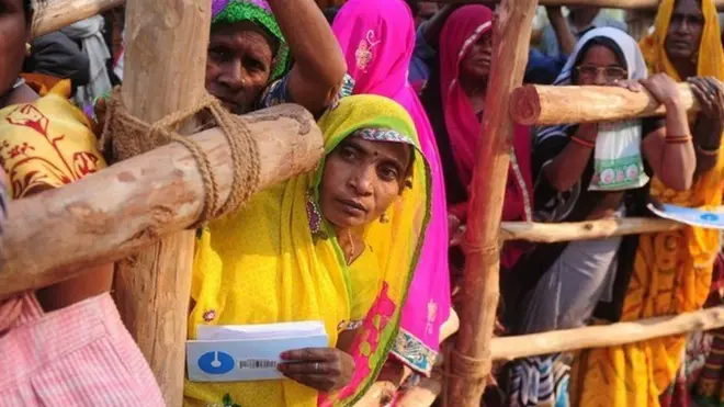 બેંકની લાઈનમાં બેરિકેડ પાછળ ઉભેલી મહિલાઓ