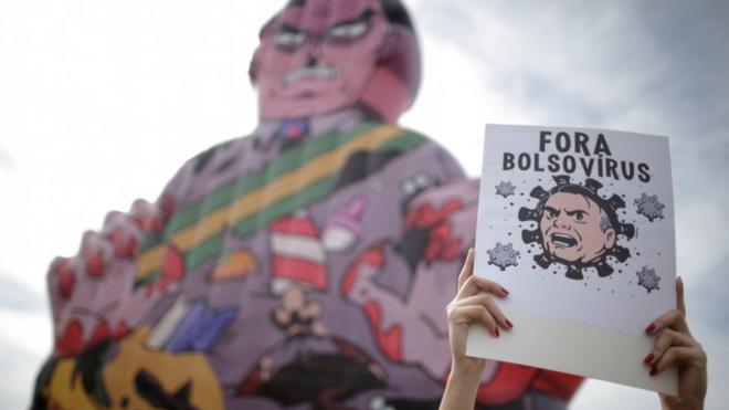Manifestante segura cartaz com dizeres 'Fora Bolsovírus'