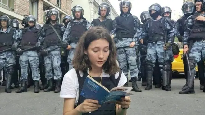 Olga Misik leyendo la constitución de Rusia de 1993 frente a la policía antidisturbios.