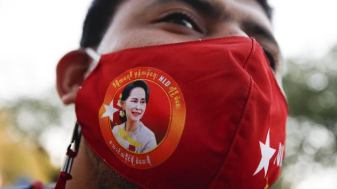 Protester wears a mask with Aung San Suu Kyi's face on it