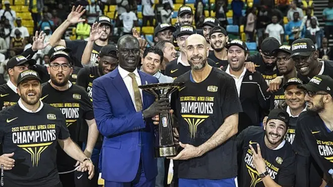 Amadou Gallo Fall remet le trophée aux vainqueurs de la BAL 2022, les joueurs de l'US Monastir.