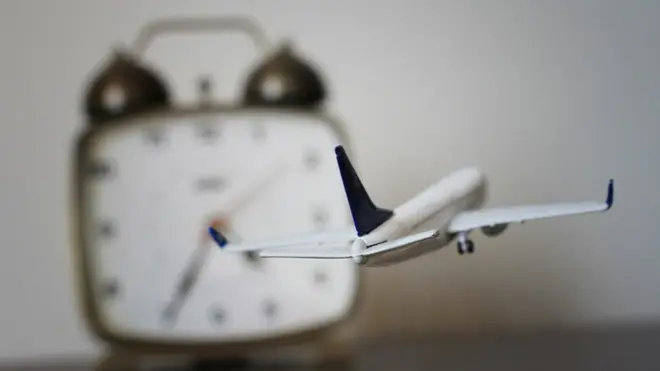 Avión con reloj de fondo.