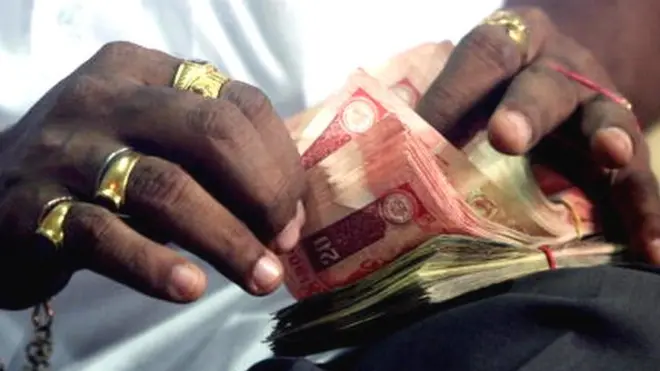 રૂપિયા ગણતો વ્યક્તિ