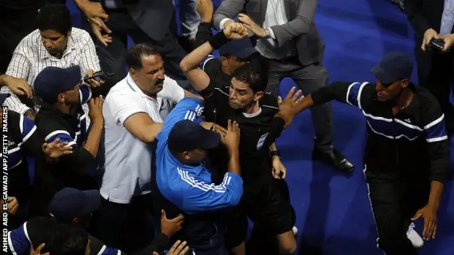 Egyptian referee Ibrahim Nour El-Din surrounded by policemen at the Alexandria Stadium