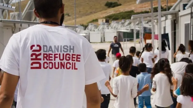 የዳኒሽ ሬፊውጂ ካውንስል ቲ-ሸርት የለበሰ