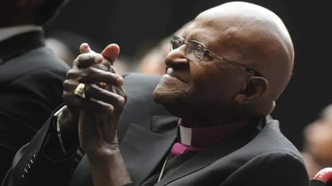 During di long years wen Nelson Mandela dey in prison, Archbishop Tutu speak out against di regime - and win di Nobel peace prize in 1984 for im efforts.