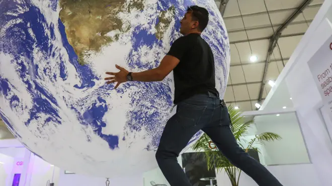 A man holds a globe at a pavilion at COP27