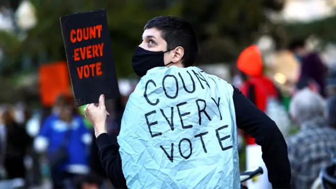 A demonstrator holds a sign while waiting to hear results after Election Day in Washington, US, 4 November 2020