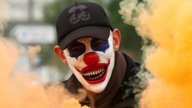 A protester wearing a mask is seen amongst smoke