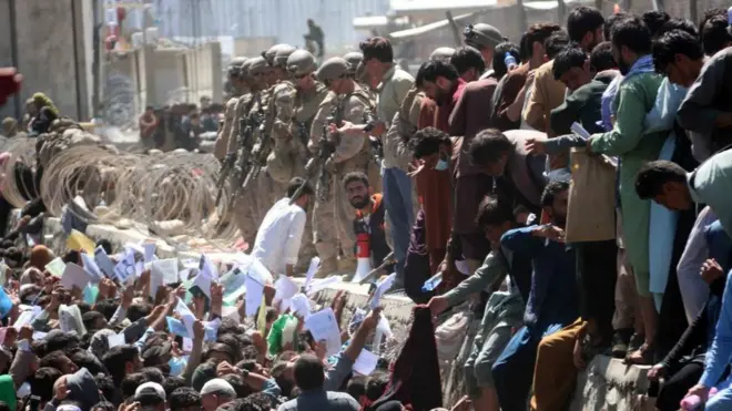 Kerumunan massa berkumpul di luar Bandara Kabul sesaat sebelum ledakan, pada 26 Agustus 2021. Mereka berharap ikut dalam pesawat evakuasi.