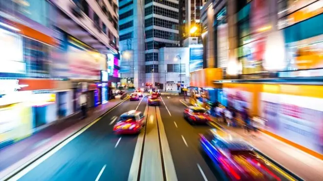 Una calle con autos circulando a alta velocidad