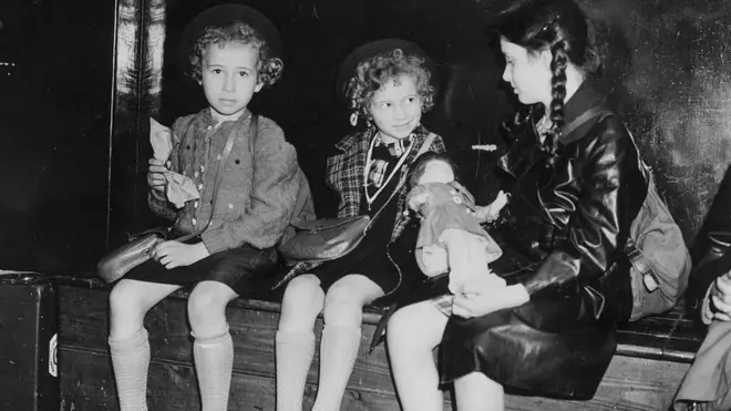 Black and white picture of three girls sitting on a bench