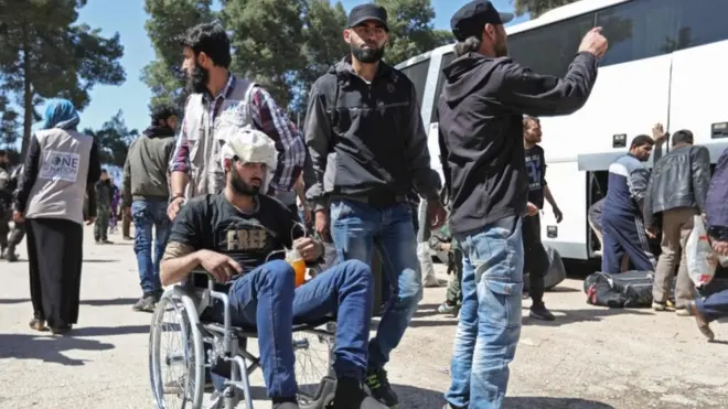 حافلات بجانبها أشخاص يستعدون للرحيل