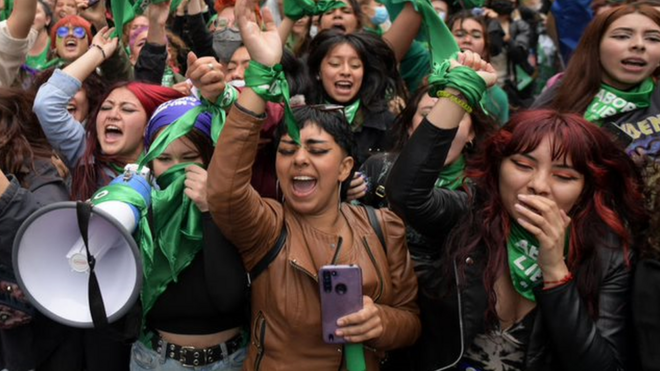 Várias mulheres erguendo os braços, gritando e sorrindobetnacional e boacomemoração