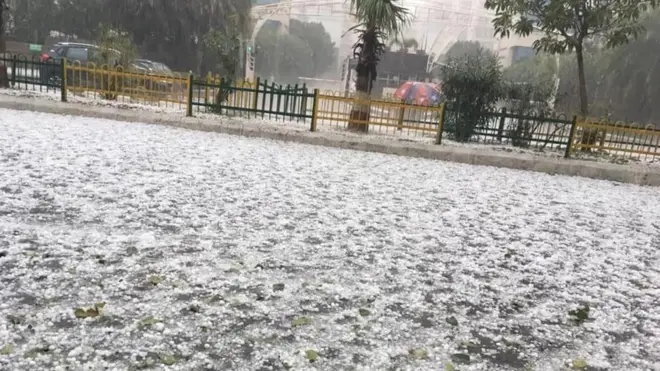 दिल्ली-एनसीआर में हुई ओलावृष्टि के बाद एक सड़क का नज़ारा