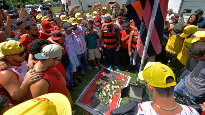 Para penggemar klub sepakbola Brasil, Flamengo berkumpul untuk meletakkan bunga di pintu masuk pusat pelatihan milik klub tersebut setelah kebakaran besar pada Jumat (08/02).