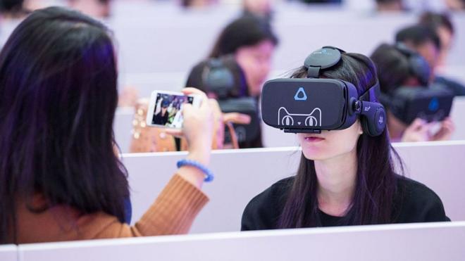 Members of the media wear virtual reality headsets and experience Alibaba's VR shopping technology Buy+ at Shenzhen Universiade Sports Centre during Alibaba Group's Singles' Day global shopping festival on November 11, 2016 in Shenzhen,