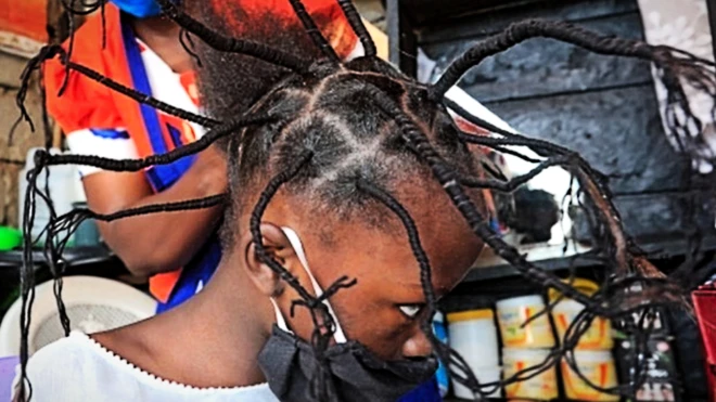 A child has her hair threaded in a salon in Kenya's capital, Nairobi - 29 April 2020