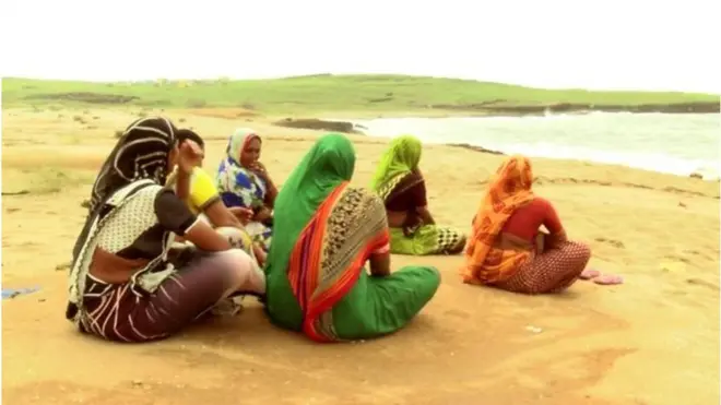 సముద్రం తీరంలో కూర్చున్న మహిళలు