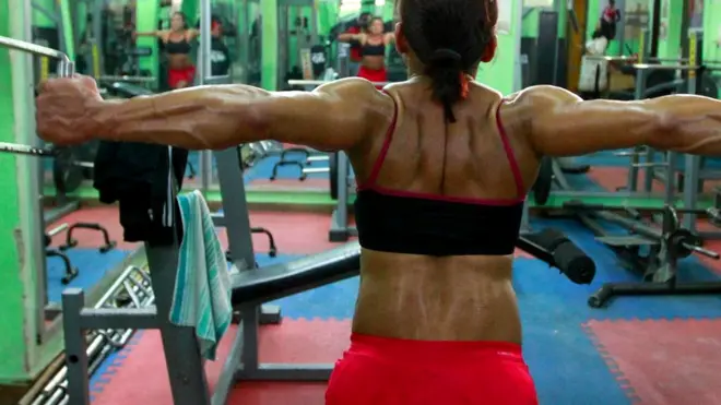 Женщина занимается на тренажерах