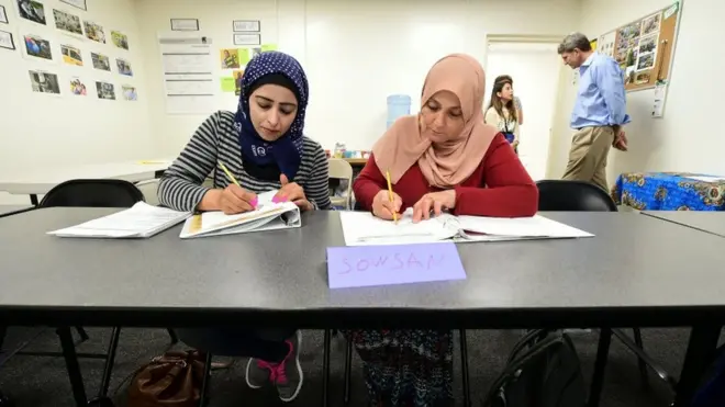 Сирийские беженцы делают заметки во время урока английского в Сан-Диего, Калифорния