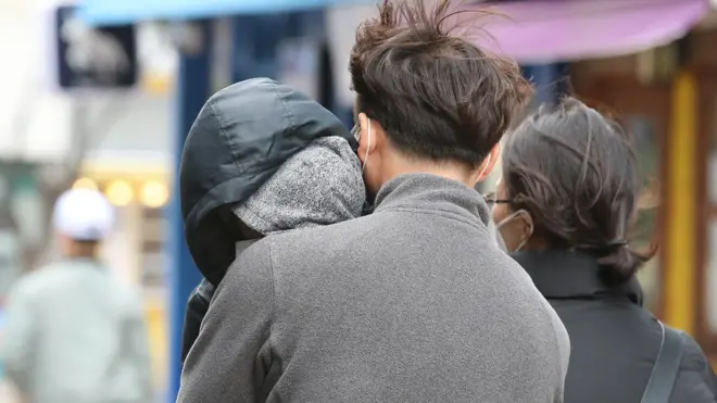 정부가 신종 코로나바이러스 감염증(코로나19) 사태와 관련해 대구·경북 지역을 특별재난지역으로 선포할 것으로 알려진 15일 오후 대구 중구 동성로에서 아이를 꼭 안은 부모가 발걸음을 재촉하고 있다